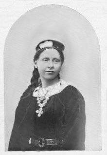 19th-century black and white portrait photo of a woman wearing a dark blouse and hat.