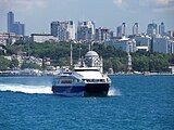 A catamaran Seabus on the Bosphorus, with the skyscrapers of Levent business district in the background. Istanbul Sapphire is the first skyscraper on the left.