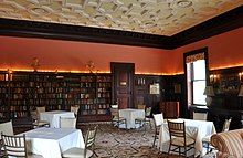 A bookshelf-lined library, with arranged tables and chairs