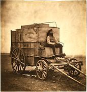 Roger Fenton's assistant seated on Fenton's photographic van, Crimea, 1855