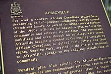 Text reads "For over a century African Canadians settled here, developing an independent community centred around church and family. As part of the urban renewal projects of the 1960s, officials introduced a plan to level the community and relocate its residents. The community mobilized and even though no buildings were saved, Africville became a symbol of the ongoing struggle by African Canadians to defend their culture and their rights. Seaview Park, created on the site as a memorial to Africville, speaks to the enduring significance of community."