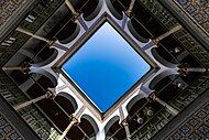 Sky seen from an open courtyard surrounded by tiled galleries