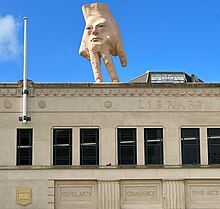 photo of giant hand sculpture on roof.