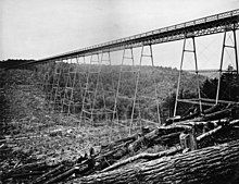 A black-and-white photo of a bridge crossing a valley