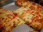 Uruguayan style pizza is like that of the image, though portions are longitudinally half as such.