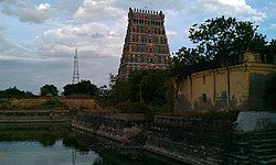 a temple tank with temple tower in the background