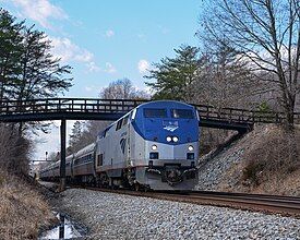 An Amtrak train passes under the bridge for Gilbert Station Road on the NS Washington District in Gilbert, Virginia.