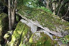 moss covered upright stones support a massive leaning stone roof slab