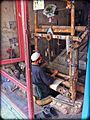 Weaving at a pit loom; the frame is built shorter, but set over a pit, so that the treadles are below ground level. Herat, Afghanistan.