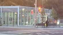 Photo of a largely completed modern light rail station entrance with glass panelling.