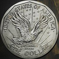 One side of a coin design, depicting an eagle flying above a mountaintop