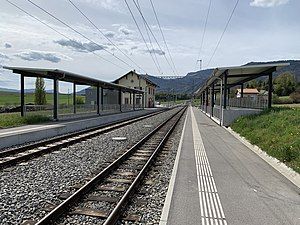 Two side platforms with shelters and two-story station building