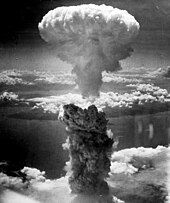 Photo of a nuclear mushroom cloud with a gray stem and white cap