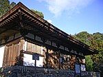 Wooden building on a stone platform with white walls.