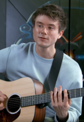 Alec Benjamin playing a guitar