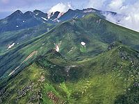 The mountains of Shiretoko Peninsula from Mount Rausu (July 2007). In the foreground is Mitsumine, in the middle field is Mount Sashirui, and in the background is Mount Iō