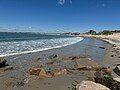 View of East Matunuck State Beach looking west from the east end by the breakwater. It shows the houses along the first part of the beach and the public pavilion in the distance.