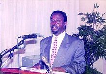 Man standing at a podium in front of microphones