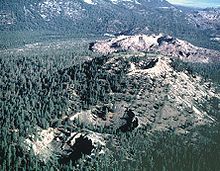 Two craters in a forested area and one crater on top of a large hill. A hummocky massive but flat hill is in the background.