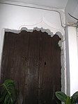 Door on the left side of the inner courtyard topped by an arch of memories of ogee arch.