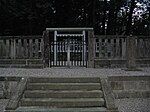 Torii behind stone fence.