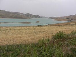 A grassy area with a body of water in the background.