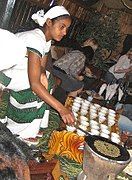 An Ethiopian woman preparing Ethiopian coffee at a traditional ceremony. She roasts, crushes and brews the coffee on the spot.