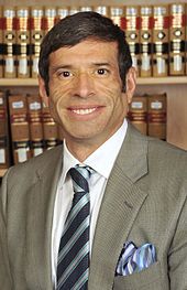 Man facing front wearing suit and necktie