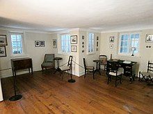 Photograph image of the Swallow's Nest, a largely empty and spacious room with many windows. Under all of them is a piece of furniture.