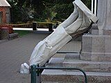 A statue toppled off its plinth