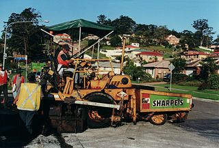 Asphalt pavers can be on wheels or tracks. Here is a small Blaw Knox wheel type paver on a residential street job.