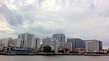 Large modern buildings, seen from a distance over water