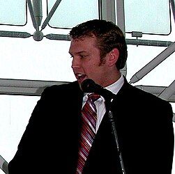 Head of the Concussion Legacy Foundation Christopher Nowinski in a suit speaking in front of a microphone