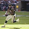 A football player running on a football field with a football