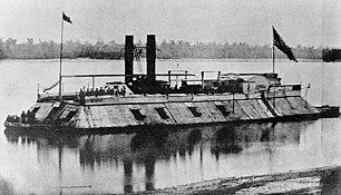 Black and white photo of a Civil War ironclad ship, the USS Carondelet, in the water. The USS Carondelet was a battleship of the United States Navy during the Civil War. It was built in 1861 and was the first battleship to use steam engines during the Civil War.