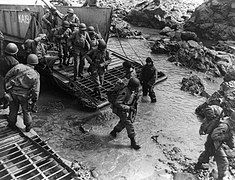 U.S Soldiers getting off their landing craft onto the rocky shores of Kiska Island