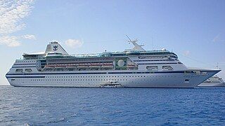 MS Nordic Empress, featuring her original Royal Caribbean livery, anchored off the Cayman Islands in March 2004