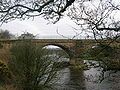 A freight train can be seen on the 'new bridge' through the arch.