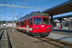 Red-and-white train next to an island platform