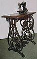 A Willcox and Gibbs sewing machine on its ornate treadle.