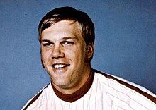 A man in a white baseball jersey