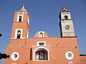 Church's two towers, one in Spanish style, other in "English" style