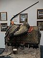 19th-century saddle on display in the museum (and historic rifle in the background)