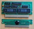 Cartridge boards without cases. The top one is an earlier version with integrated memory chips.