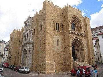 Coimbra Cathedral, with crenellated tops and heavy buttresses giving it a castle like appearance.