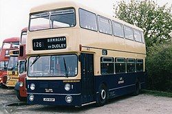 front quarter view of double-decker bus painted dark blue on the bottom and cream at the top