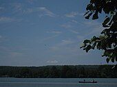 View of canoers in and an osprey over a body of water in the park