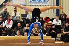 Jonna Adlerteg performing a press handstand on the balance beam