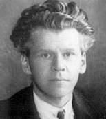 Black and white photograph of the bust of a Caucasian man wearing a white shirt, tie and coat with wavy, pulled-back hair and an abstracted gaze