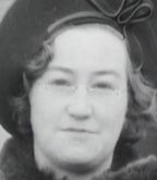 Face of a white woman, wearing a hat and glasses.